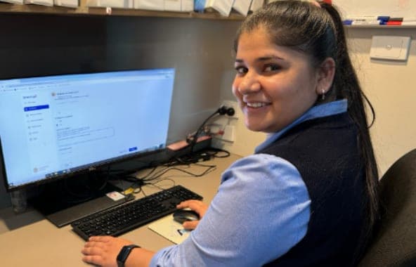 A Brenna customer's staff member creating an update at her desk